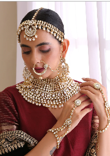 A person wearing a necklace and earrings

Description automatically generated